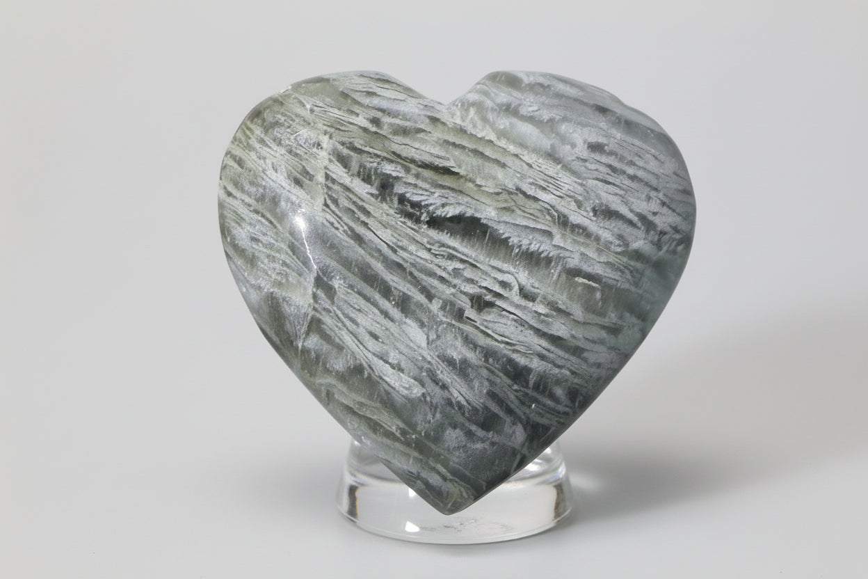 thousand layer garden quartz carved heart in a glass stand