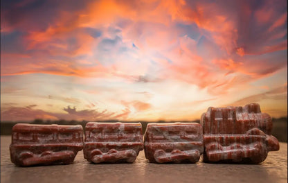 Red Jasper four piece carved train set with a sunset behind 