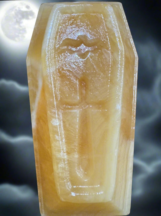 Amber-colored coffin against a moonlit, stormy backdrop.
