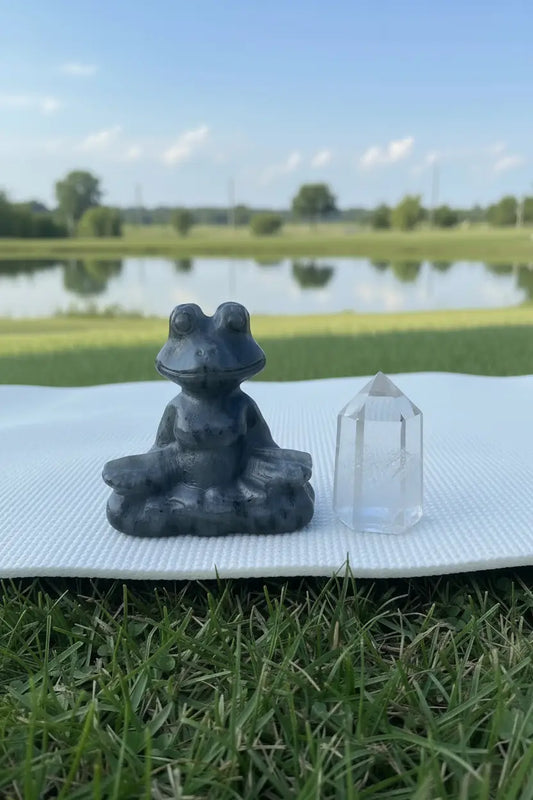 Carved Larvikite yoga pose frog sitting on a crystal 