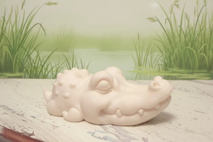 Carved tagua nut crocodile with a pretty marsh behind 
