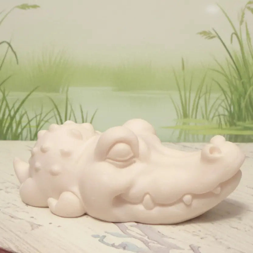 Carved tagua nut crocodile with a pretty marsh behind 
