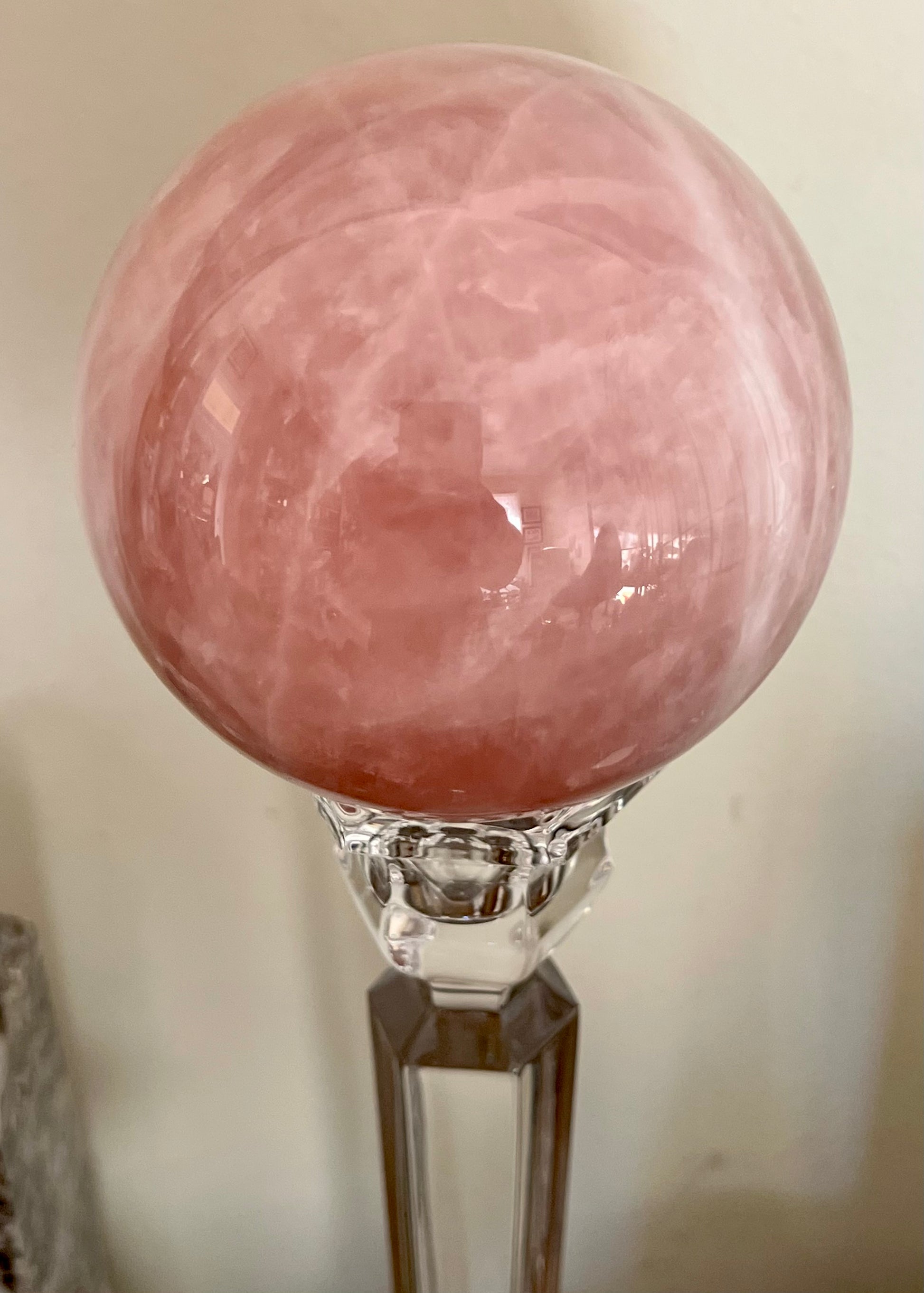 Pink crystal ball on glass stand.