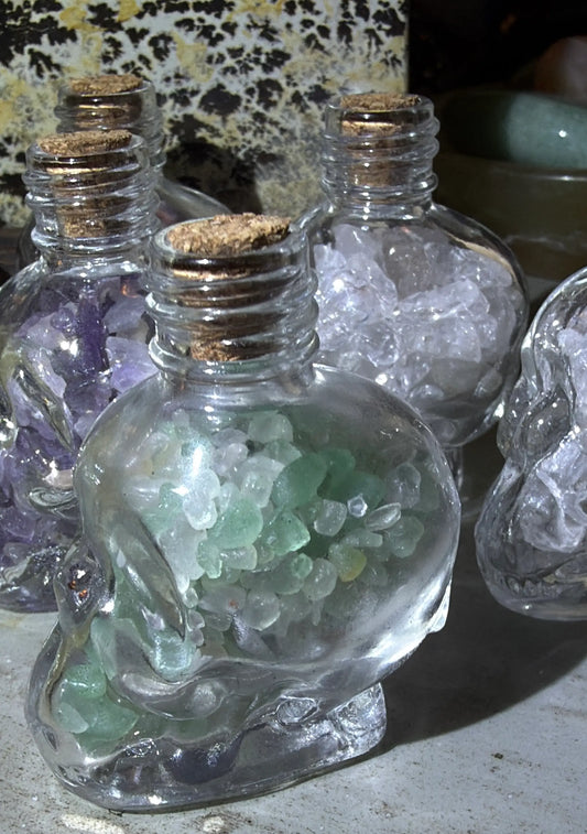 Green Chalcedony chips in a glass skull shaped wish bottle with a cork 