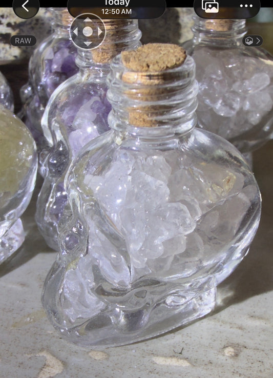 Clear quartz crystal chips in a skull shaped bottle with a cork 