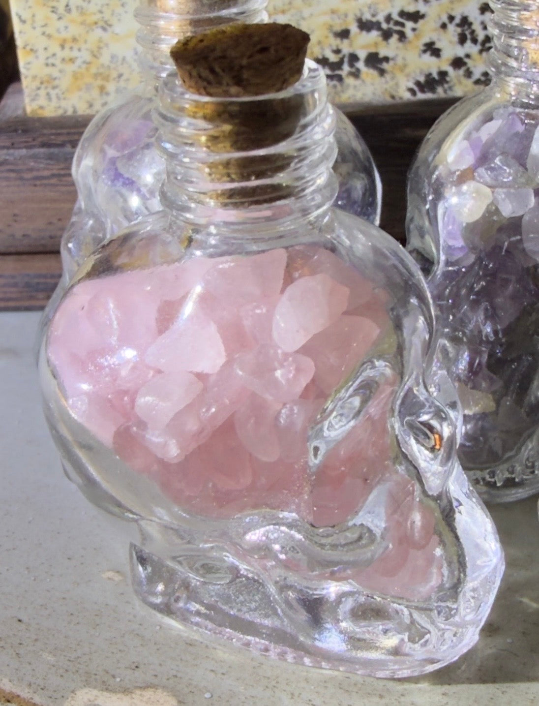 Rose Quartz crystal chips in a glass skull shaped wish bottle 