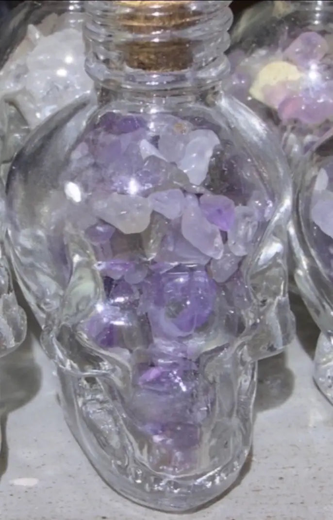 Amethyst crystal chips in a skull shaped glass wish bottle 