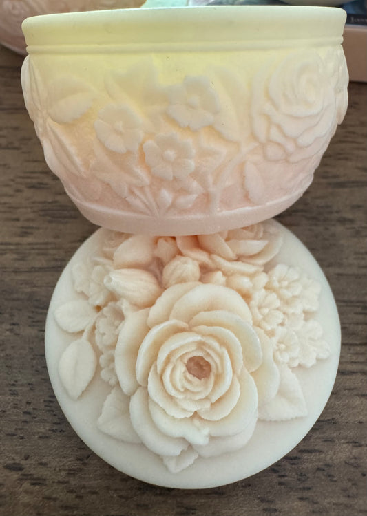 Close-up of a carved ivory soap dish with floral design.
