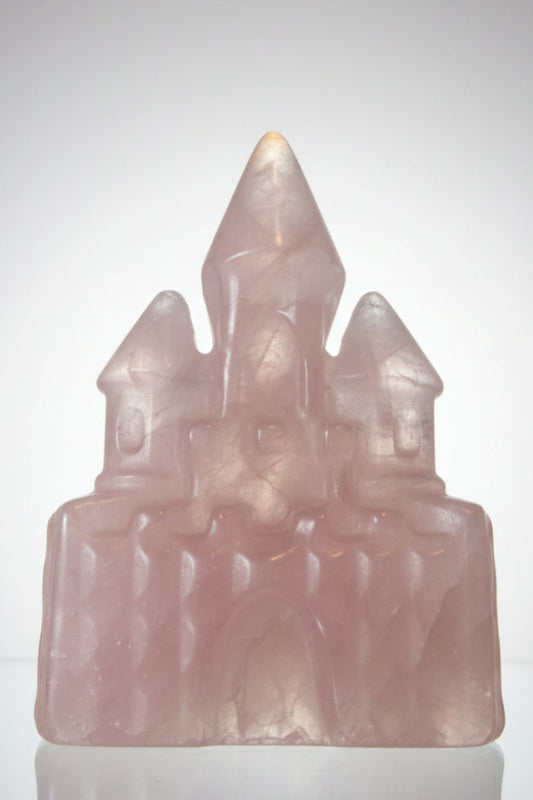 rose quartz carved castle on a glass table