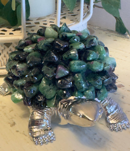Silver turtle figurine with a shell made of polished green and black stones.