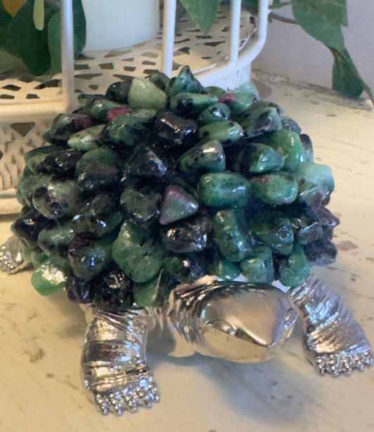 Silver turtle figurine with a shell made of polished green and black stones.