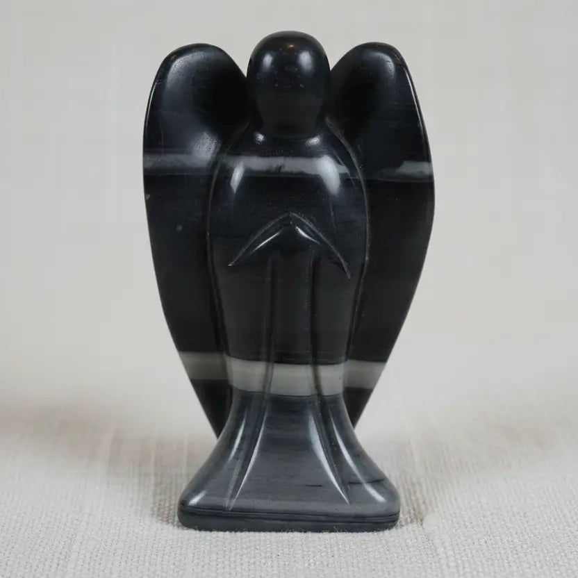 close up of taichi carved angel.  stone has gray, off white, and black banding through out.  