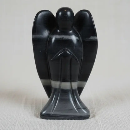 close up of taichi carved angel.  stone has gray, off white, and black banding through out.  