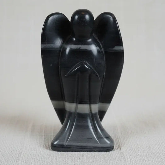 close up of taichi carved angel.  stone has gray, off white, and black banding through out.  
