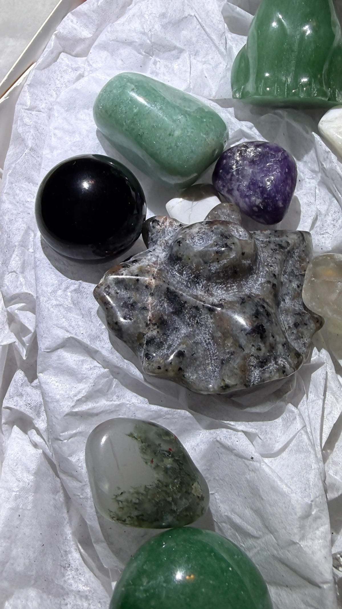Close up yooperlite carved bag and assorted polished tumbles