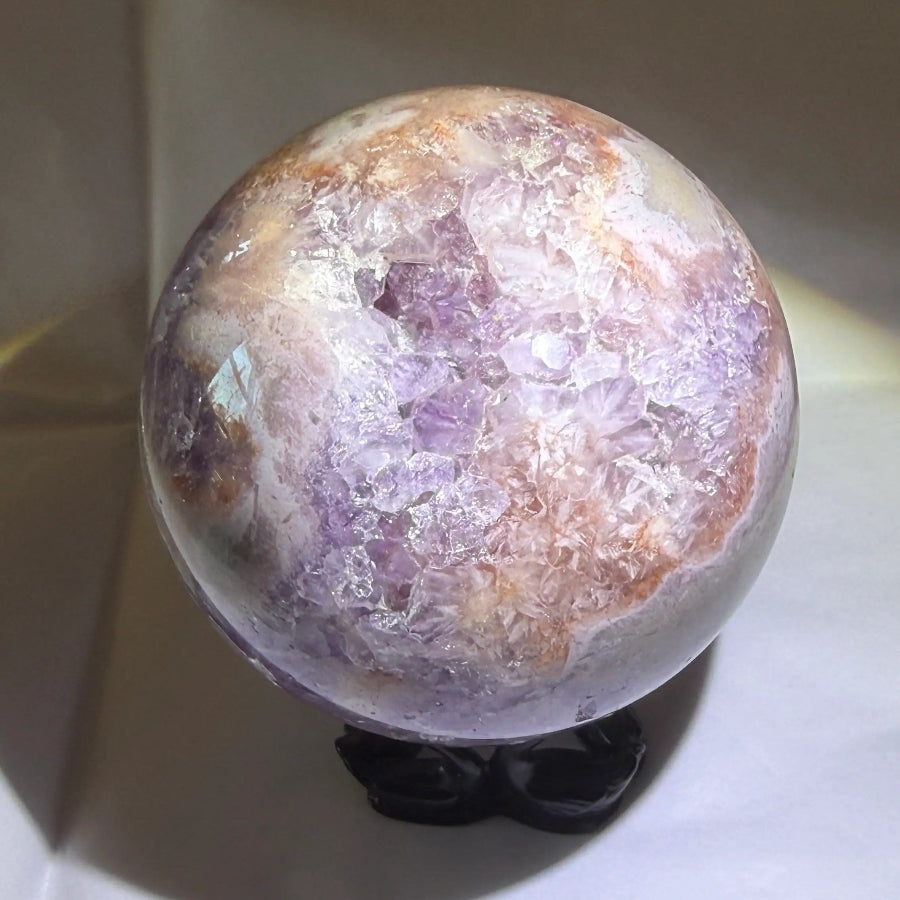 close up photo purple amethyst sphere with natural inclusions
