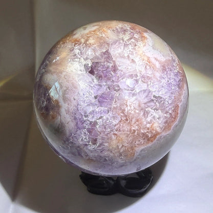 close up photo purple amethyst sphere with natural inclusions