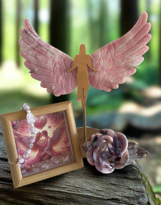 Genuine Pink Opal hand carved Angel Wings, Shadow Box with Lovers design art bright colors pink Rose Quartz Tumble Stones inside, Rose Quartz Bead Bracelet, Carved Pink Amethyst and Flower Agate Rose all places on a Tree Stump with green forest background