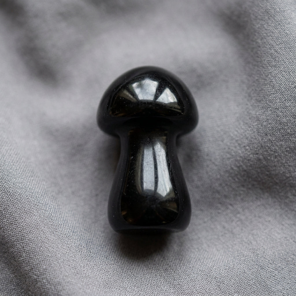Mushroom carving figurine, made from Black Agate resting on a gray background