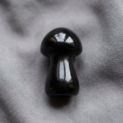 Mushroom carving figurine, made from Black Agate resting on a gray background