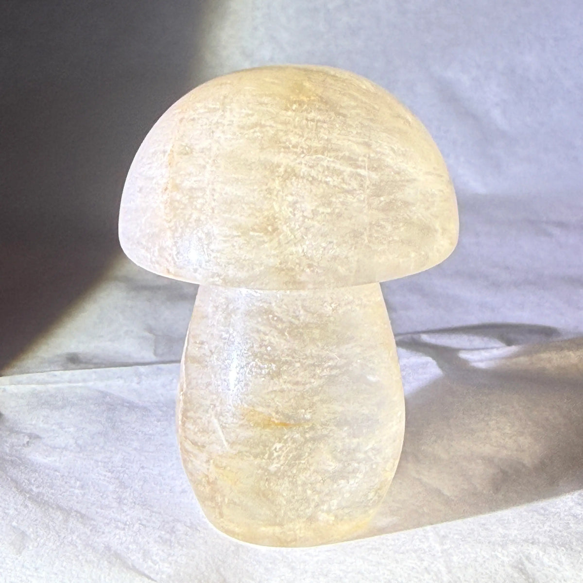 close up product photo of hand carved crystal mushroom.  material is citrine crystal. bright yellow, natural citrine