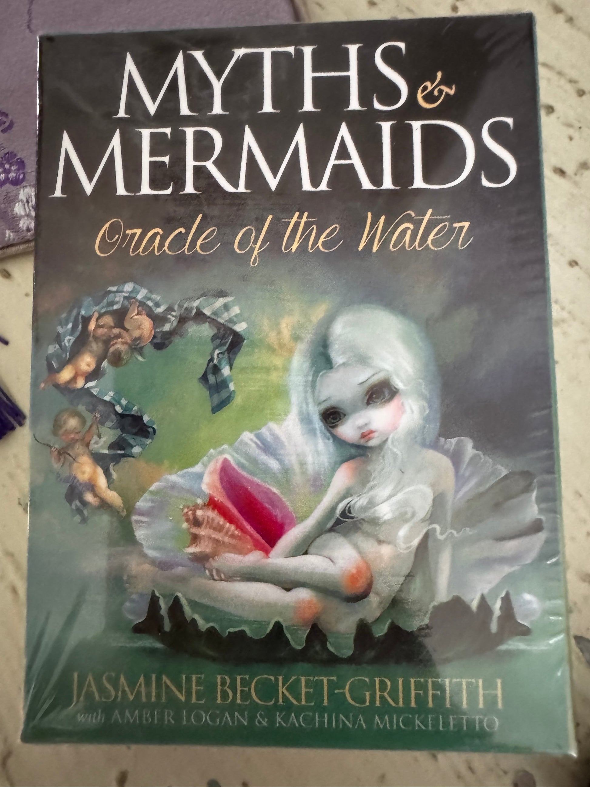 Sealed oracle deck, "Myths & Mermaids," with fantasy art by Jasmine Becket-Griffith, featuring cherubs, a mermaid, and a seashell.