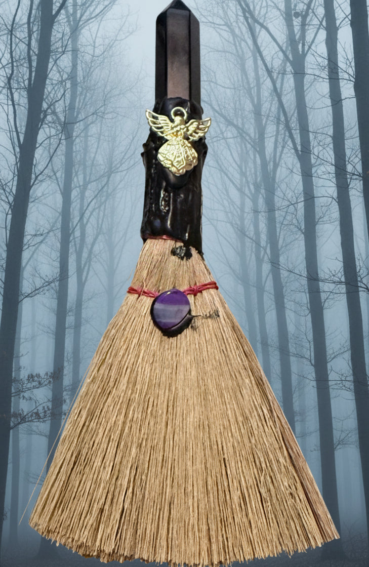 Small besom natural bristles gold tone angel charm black obsidian finial  background muted foggy forest