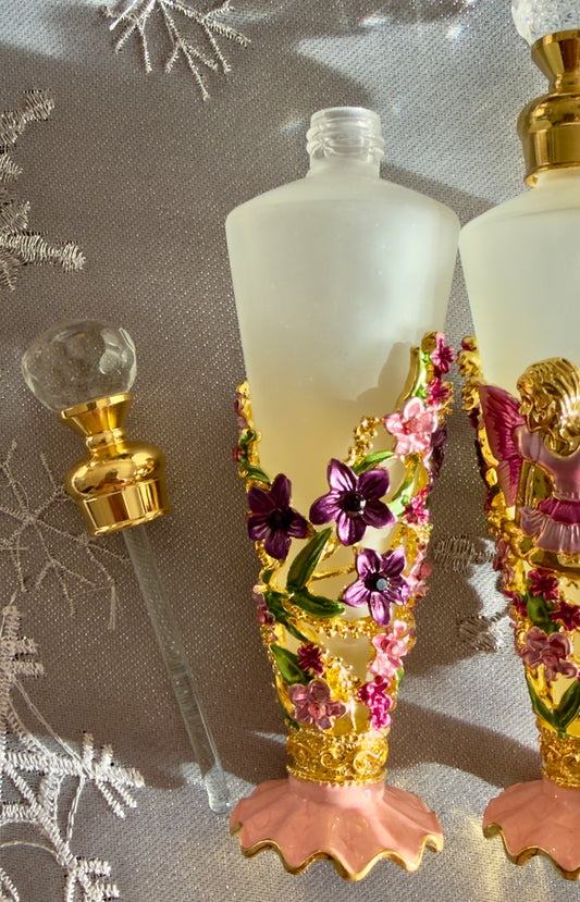 close up of frosted glass fragrance bottle flowers, lid with glass rod applicator