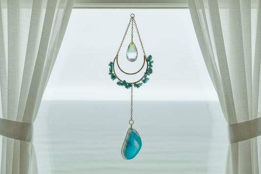 Turquoise and agate suncatcher crystal window prism on wooden background