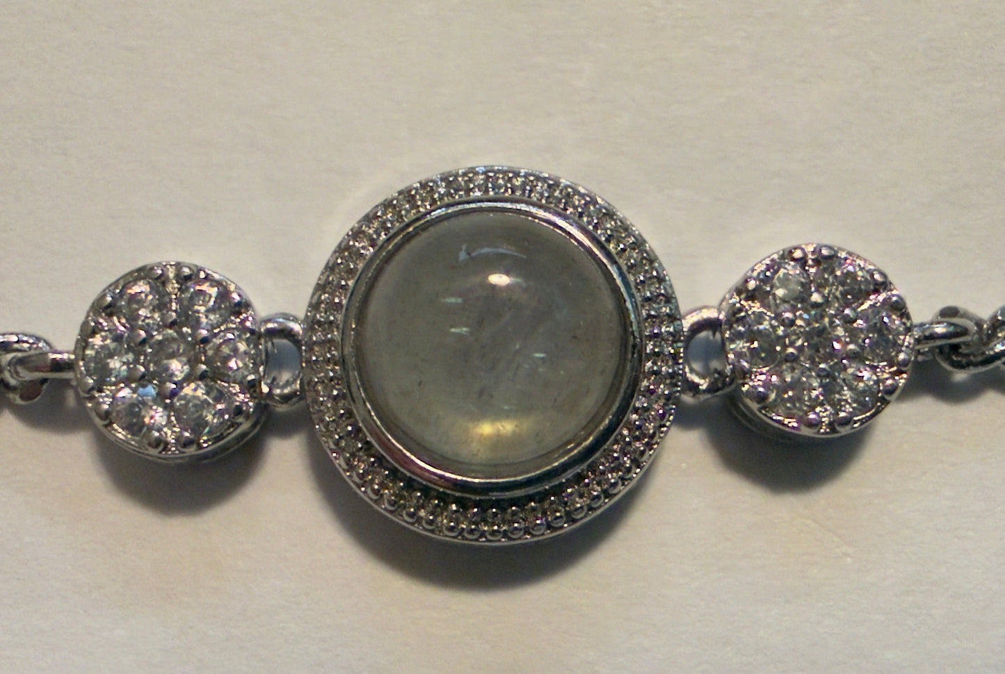 Silver bracelet with circular charms on a light background