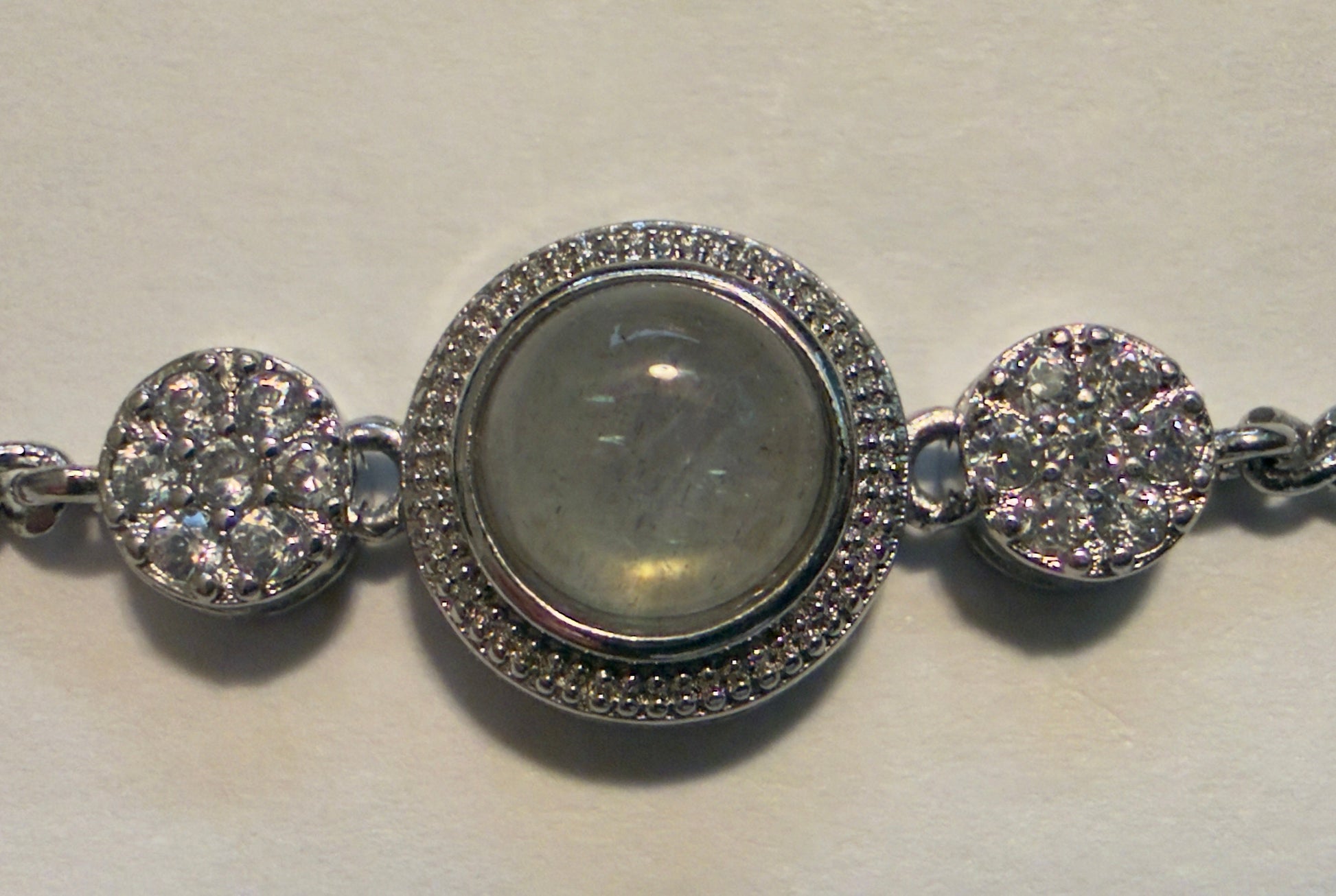 Silver bracelet with circular charms on a light background