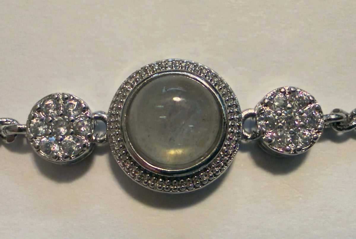 Silver bracelet with circular charms on a light background