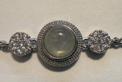 Silver bracelet with circular charms on a light background