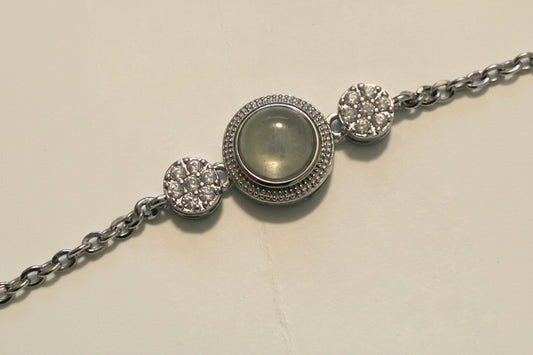 Silver bracelet with a central gemstone on a light beige background