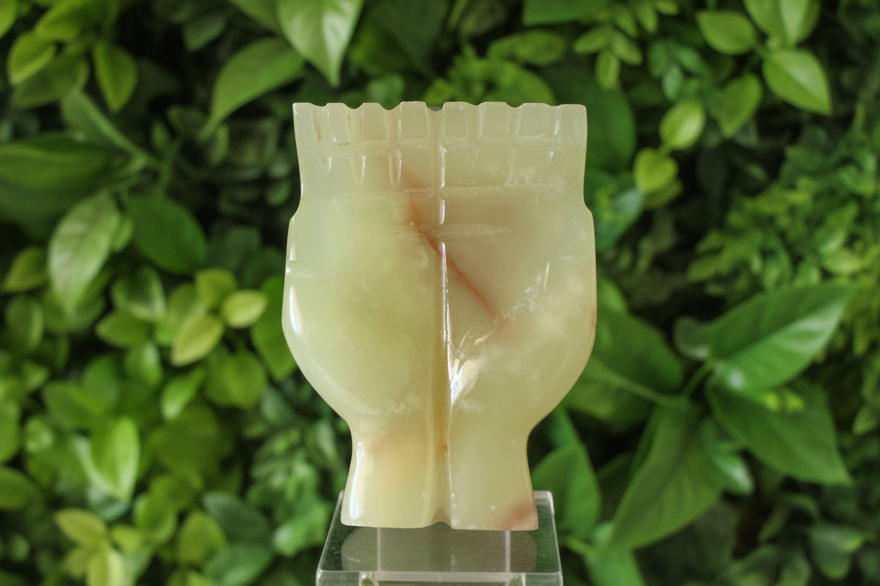 green onyx offering hands sculpture with green leaves behind