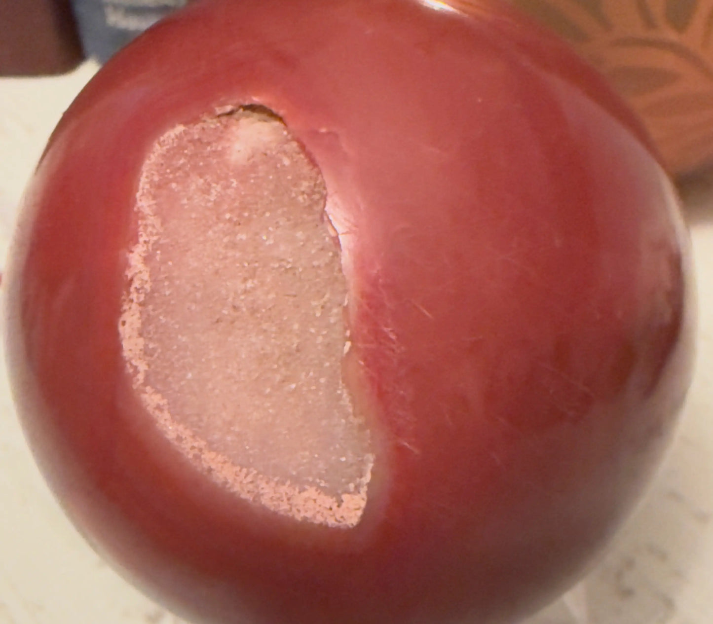Carnelian sphere with druzy pocket and orange banding close-up
