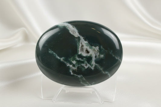 close up of a green jasper with druzy pocket, palm stone dark green with white streaks 