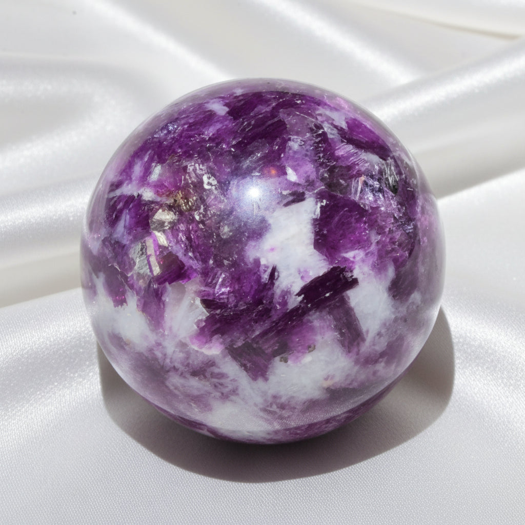 A polished lepidolite crystal sphere with prominent purple and white fluorite inclusions 
