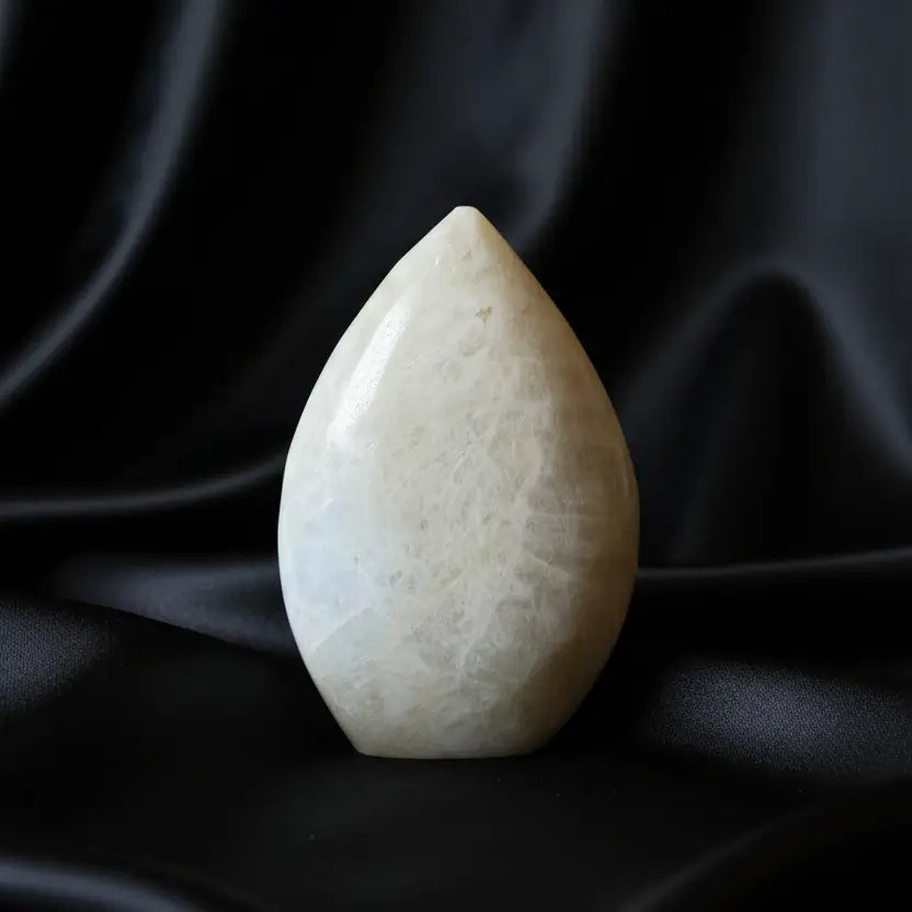A teardrop-shaped white moonstone freeform with natural marbled textures