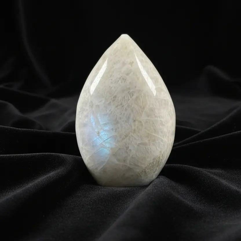 A teardrop-shaped moonstone carving with natural crystalline texture 