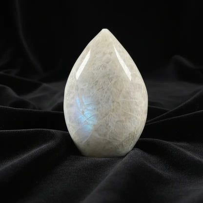 A teardrop-shaped moonstone carving with natural crystalline texture 