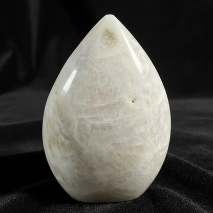 A teardrop-shaped moonstone freeform with a black background