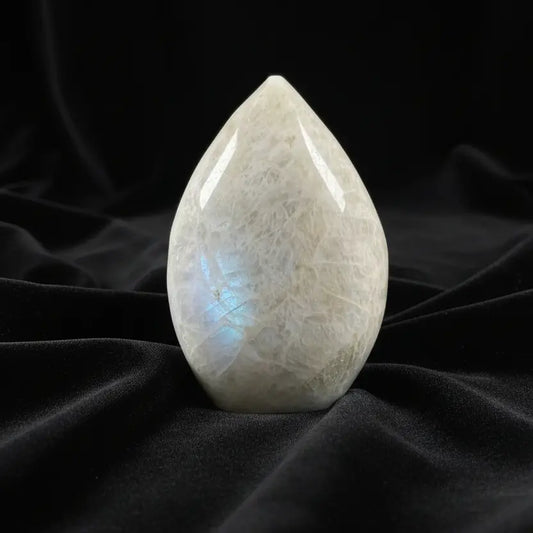 A teardrop-shaped moonstone carving with natural crystalline texture 