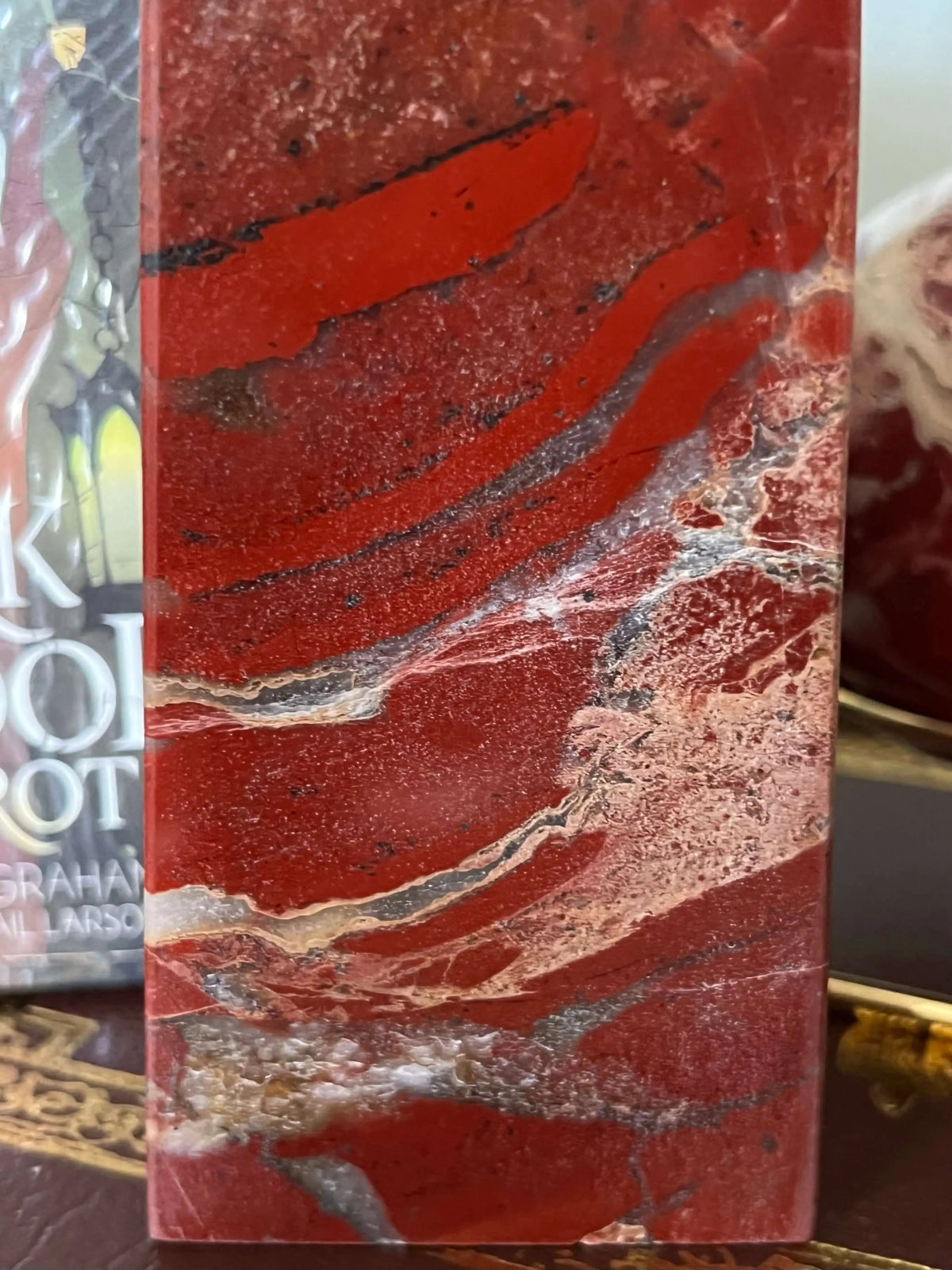 Close-up of polished red jasper with white and grey veining.