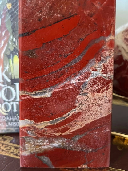Close-up of polished red jasper with white and grey veining.