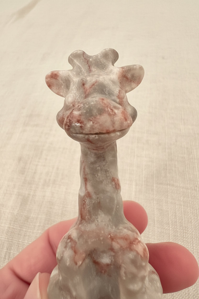 close up giraffe face and figurine  Hand carved red vein jasper crystal. pretty pinks weave through the cream color jasper