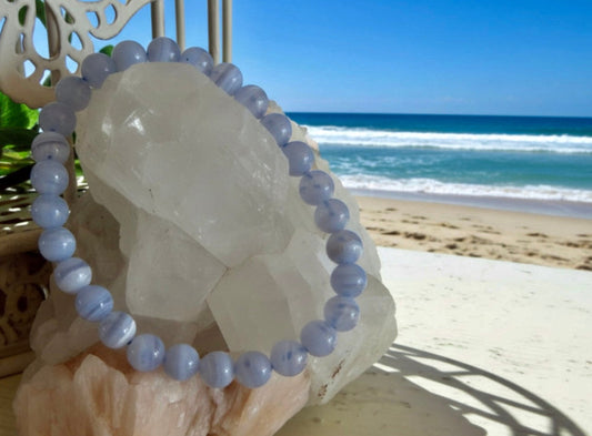 Blue Lace Agate 7 mm Bead Bracelet on a beach setting with ocean in the background