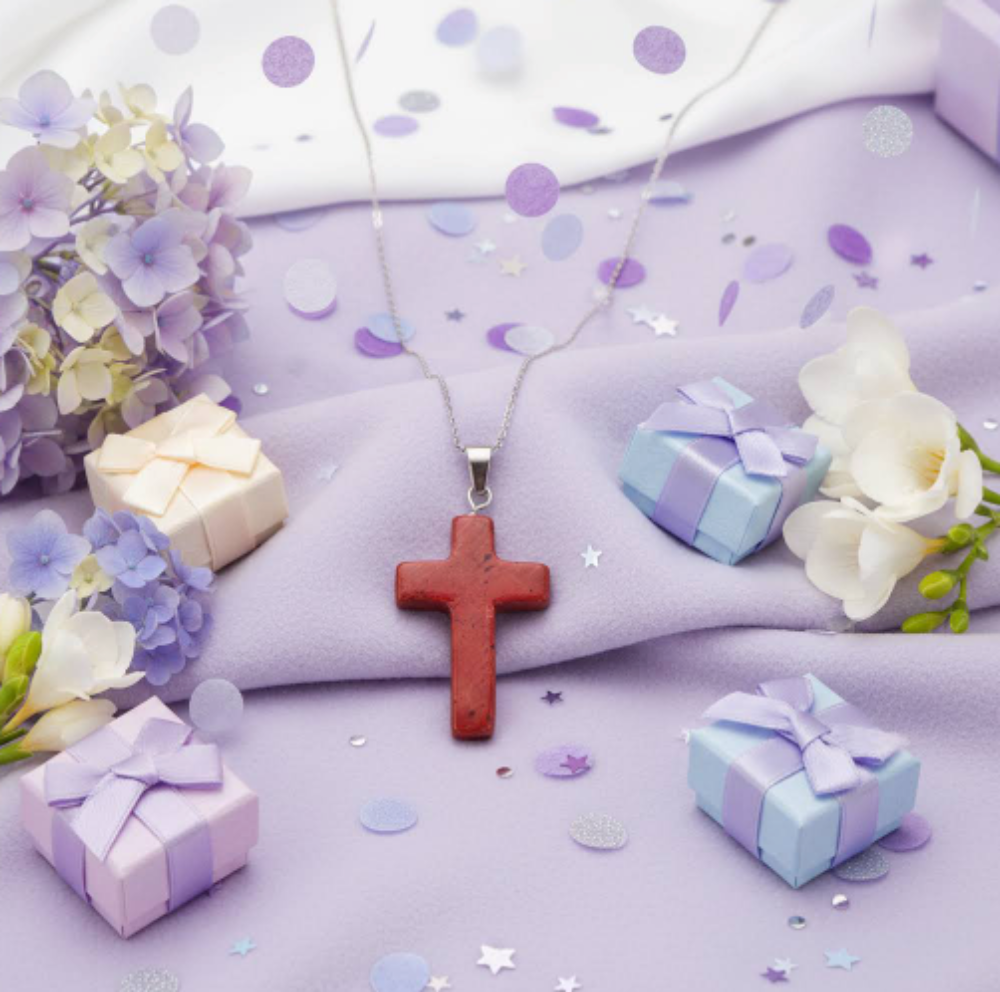 Pretty Red Jasper carved cross pendant with a lavender background lavender gift boxes and flowers 