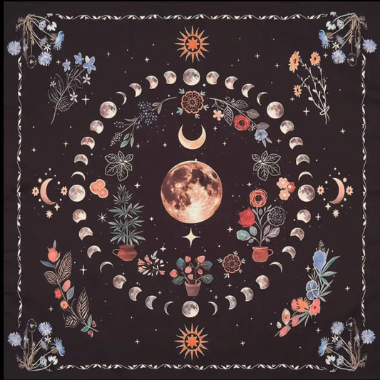 close up photograph is altar cloth. printed moon phases, a full moon, blue flowers in each corner of the fabric