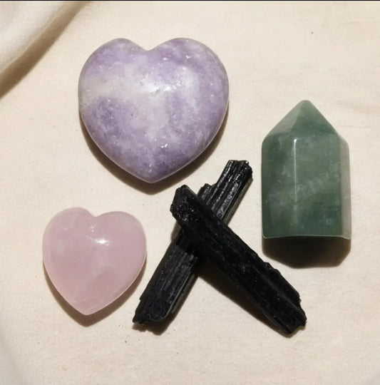 close up photo lepidolite heart, rose quartz heart, black tourmaline specimen pieces and a mini carved crystal tower/charge made from aventurine